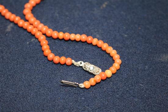 A single strand graduated coral bead necklace and a carved coral ring.